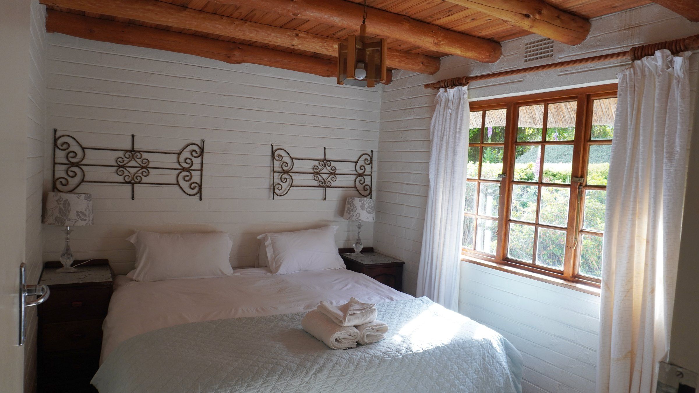A downstairs bedroom with a double bed and a window onto the garden