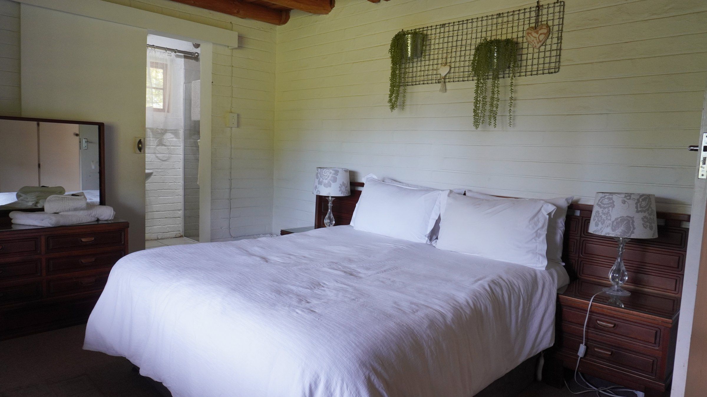 A downstairs bedroom made up as a double, with the en-suite through the open door