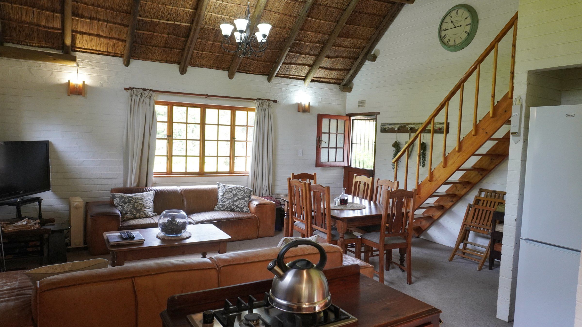 The lounge and dining table, with wooden stairs rising to the loft