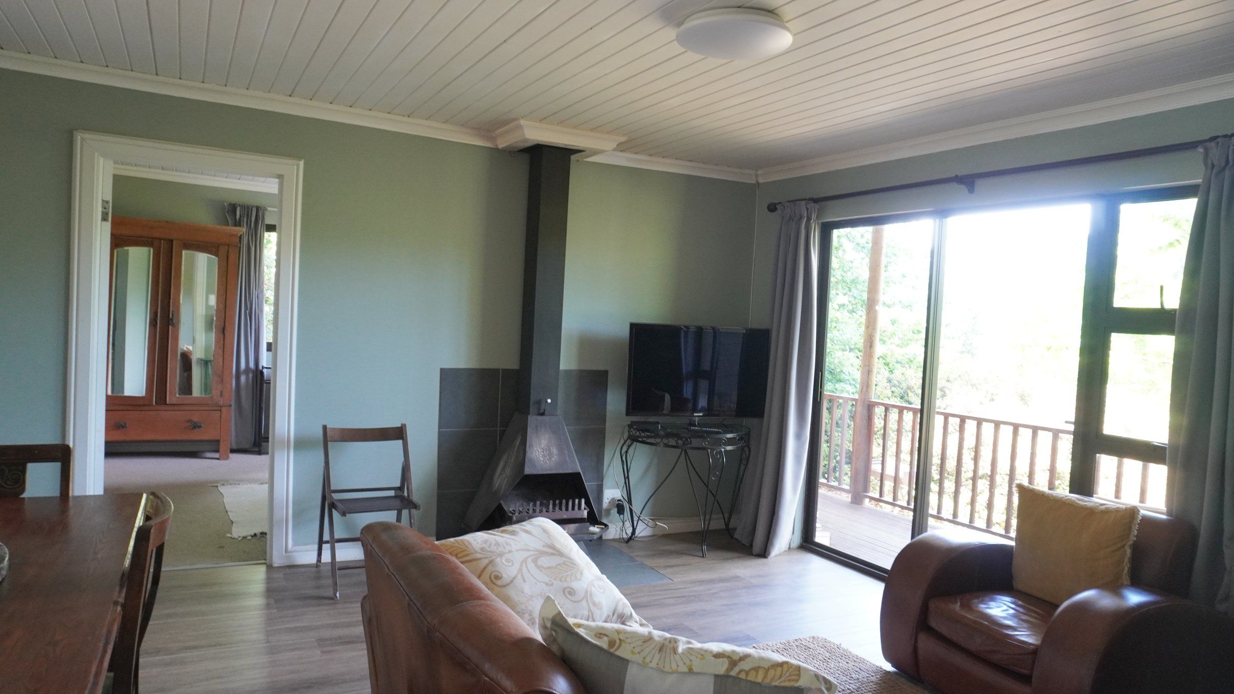 EverGreen Lodge's lounge with a wood-burning stove, leather chairs and sliding doors onto the verandah