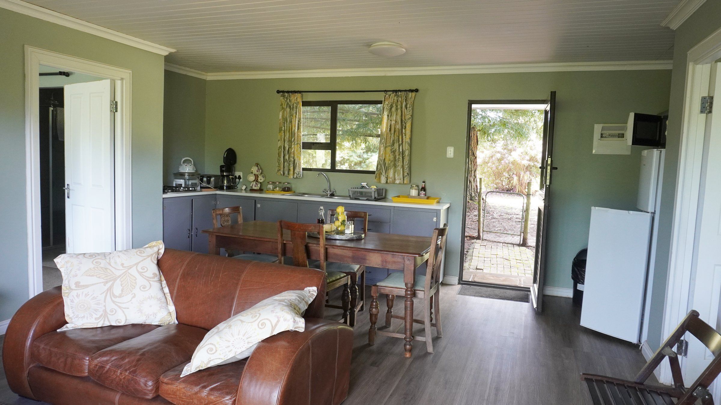 EverGreen Lodge's open-plan lounge, dining table and kitchen, with a stable door to the garden