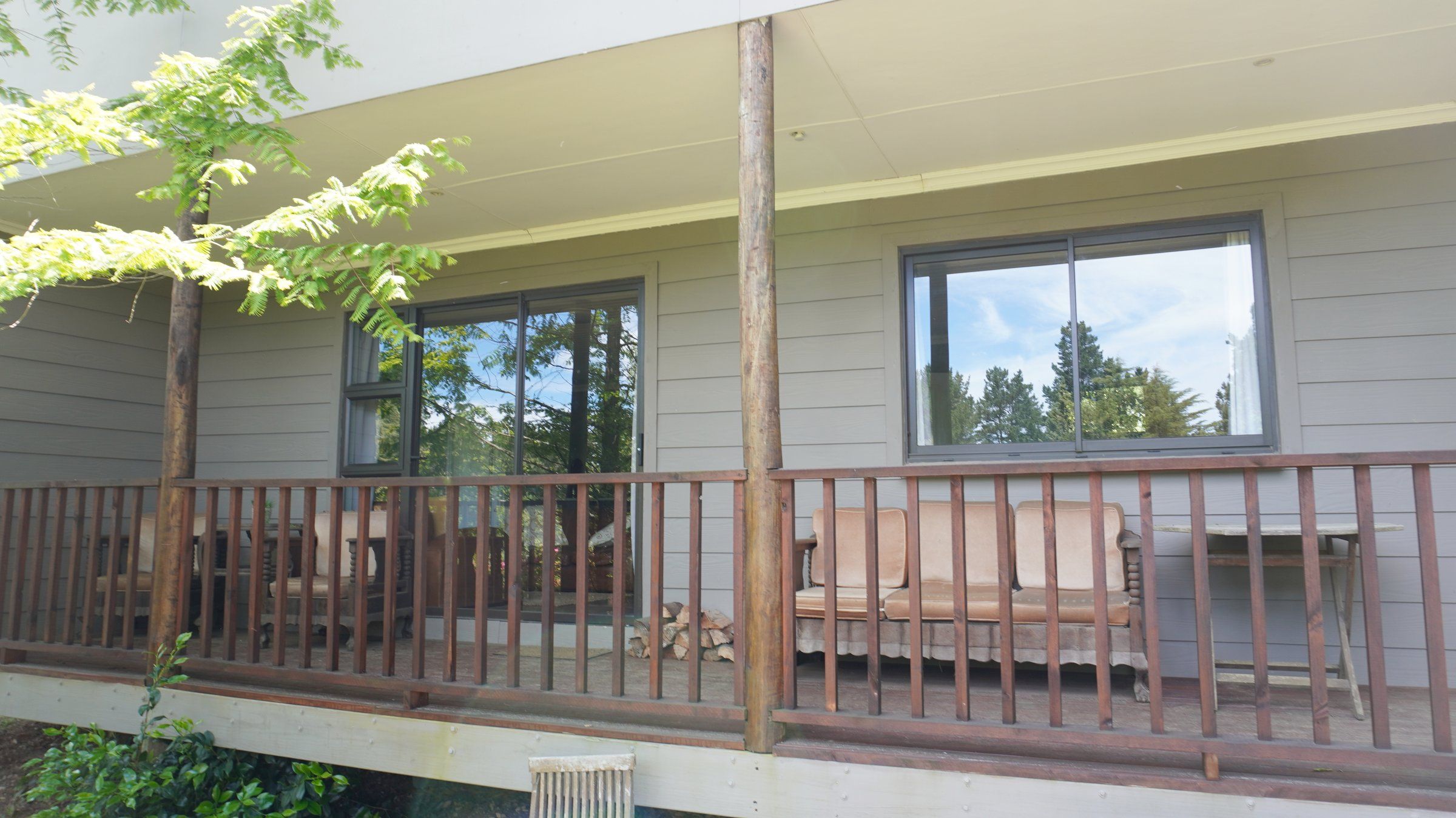 EverGreen Lodge's verandah with a sofa and table, looking into the lounge